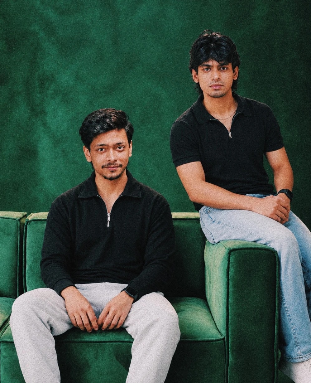 Payriz founders Fahmid and Rakib sitting on a green sofa